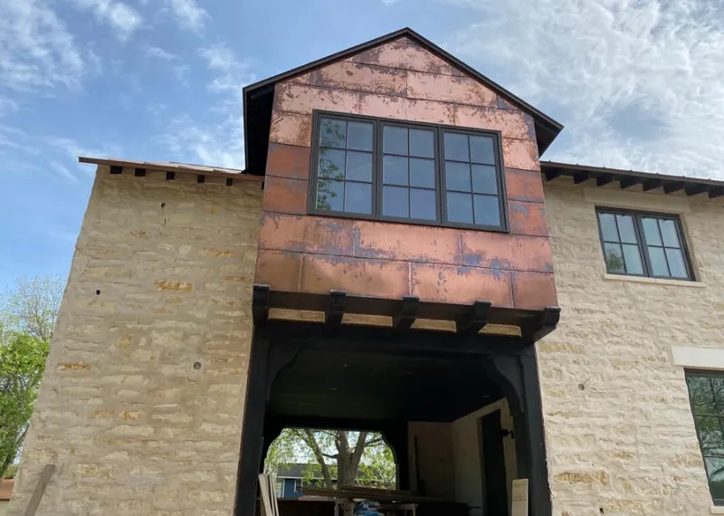 Copper metal panel facade on a stone building for Roof Repair in Delta